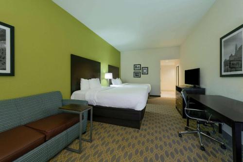 a hotel room with a bed and a desk at La Quinta by Wyndham Columbus - Grove City in Grove City