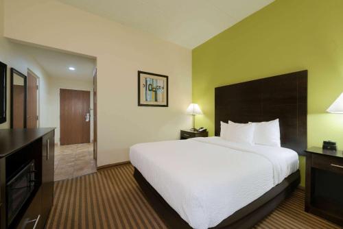 a hotel room with a large bed and a television at La Quinta by Wyndham Columbus - Grove City in Grove City
