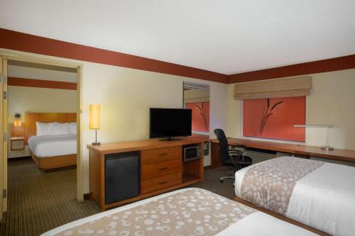 a hotel room with two beds and a flat screen tv at La Quinta by Wyndham Springdale in Springdale