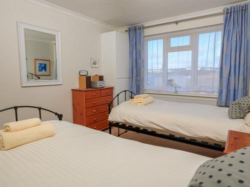 a bedroom with two beds and a window at 7 Thurlestone Rock in Kingsbridge