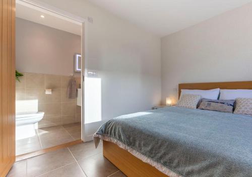 a bedroom with a large bed and a bathroom at Stones Throw Studio Apartment Bude Cornwall in Bude