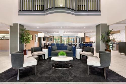 a lobby with couches and a table and chairs at Wingate By Wyndham Montgomery in Montgomery