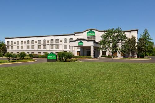 a white building with a lawn in front of it at Wingate By Wyndham Montgomery in Montgomery