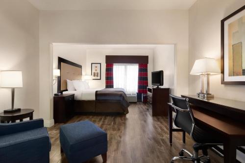 a large hotel room with a bed and a couch at Wingate By Wyndham Montgomery in Montgomery