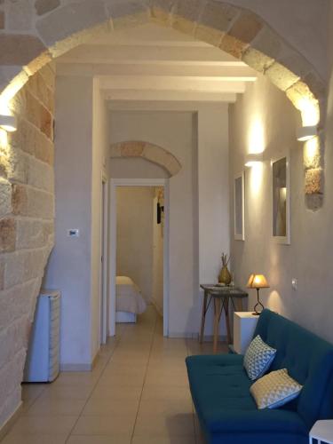 a living room with a blue couch and a stone wall at B&B Casa Dorsi in Polignano a Mare