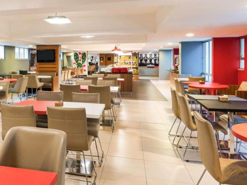 a dining room with tables and chairs in a restaurant at ibis Fortaleza Praia de Iracema in Fortaleza