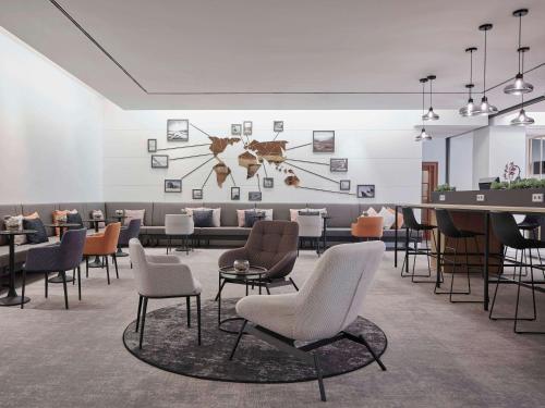 a waiting room with chairs and a table at Hotel Mondial am Dom Cologne MGallery in Cologne