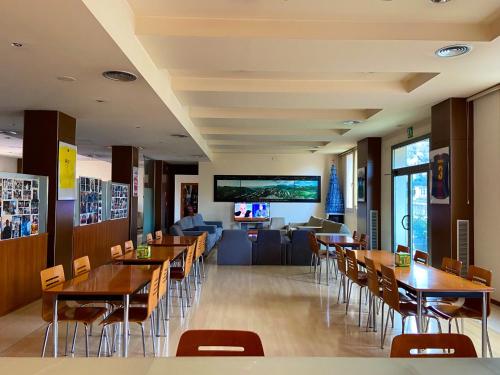 a restaurant with tables and chairs and a couch at Hotel Berga Park in Berga