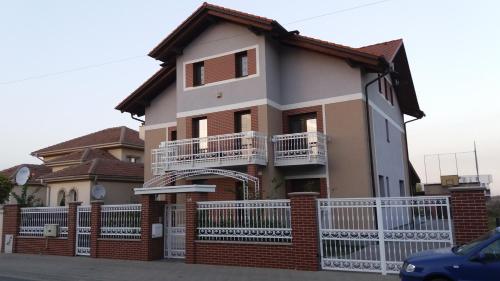 een huis met een wit hek ervoor bij Single Suite Apartment in Timişoara