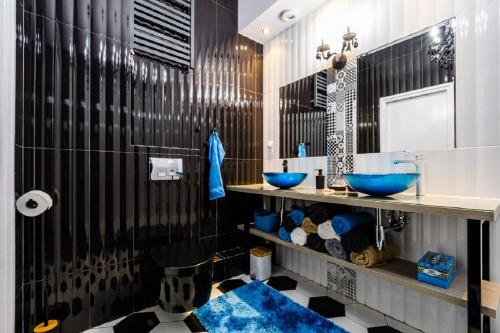 a bathroom with two blue sinks and black and white tiles at Blue House Warsaw Center in Warsaw