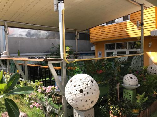 un patio avec une table et de nombreuses plantes dans l'établissement GATE 14 Inn, à Nakhon Phanom