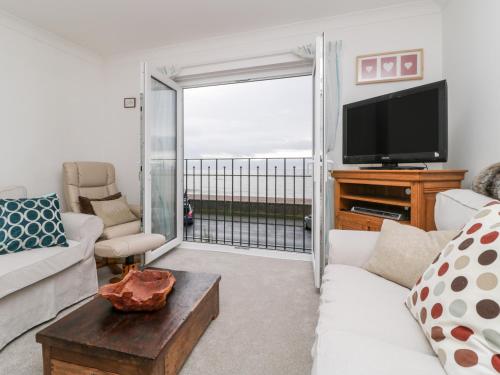 a living room with a couch and a tv at 14 Lyme Mews in Seaton