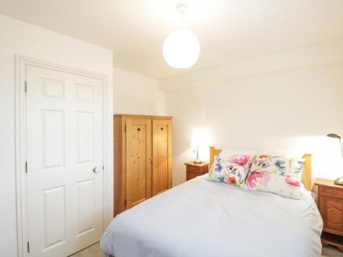 a bedroom with a white bed with pillows at 14 Lyme Mews in Seaton