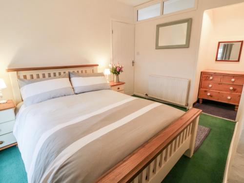 a bedroom with a large bed and a dresser at Little Piccadilly in Totnes