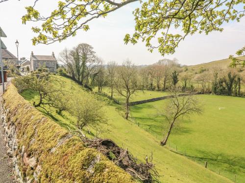 a grassy hill with trees and a field at Bank End Cottage in Carnforth