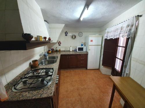 a small kitchen with a stove and a sink at Casa Rural Ramos in Linares de la Sierra