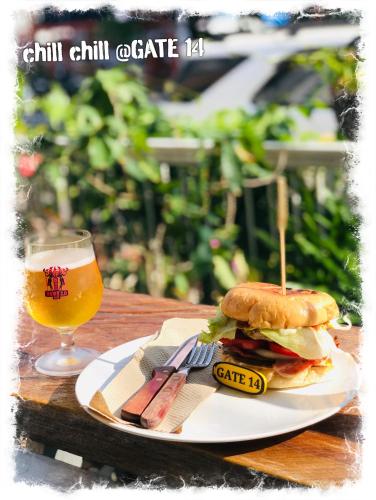 a sandwich on a plate next to a glass of beer at GATE 14 Inn in Nakhon Phanom