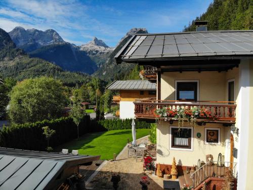 a house with a balcony with a view of mountains at Apartments Landhaus Sonnheim in Lofer