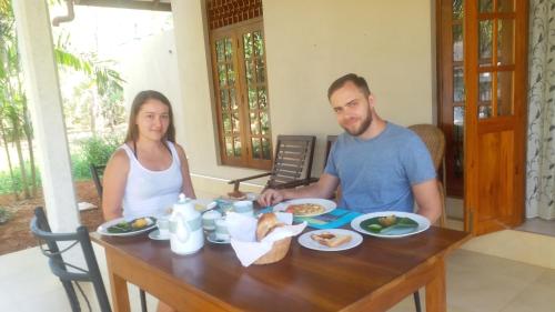 a man and a woman sitting at a table with food at CASA VACANSA HOME STAY in Hungama