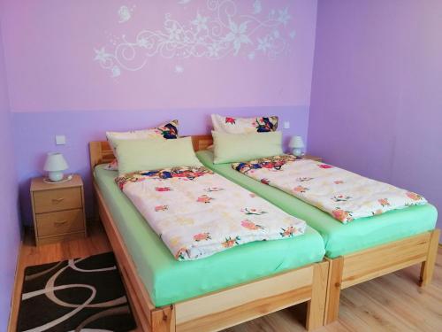 two twin beds in a room with purple walls at Ferienwohnung Am Apelsberg in Neuhaus am Rennweg