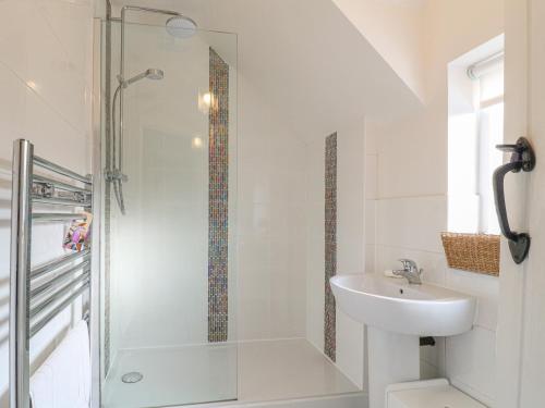 ein weißes Badezimmer mit Waschbecken und Dusche in der Unterkunft Lavender Cottage in Ilkeston