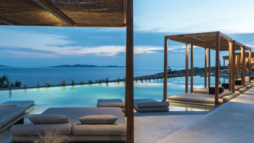 a swimming pool with a view of the ocean at Rocabella Mykonos Hotel in Agios Stefanos