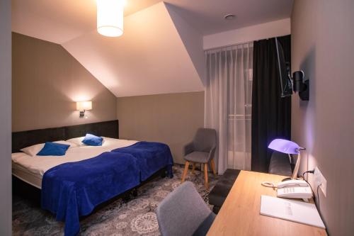 ソレツ・ズドルイにあるHolisticのベッド、デスク、椅子が備わるホテルルームです。