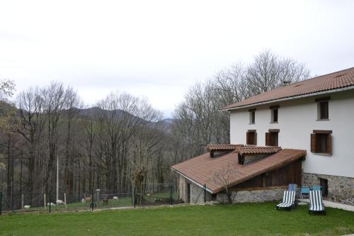 a house with two lawn chairs in front of it at CASA RURAL Arriaran in Leitza