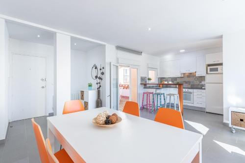 una cocina blanca con mesa blanca y sillas naranjas en Apart-rent Apartment Gran Reserva 0061, en Empuriabrava