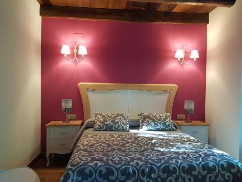 a bedroom with a bed with purple walls and lamps at CASA RURAL Arriaran in Leitza
