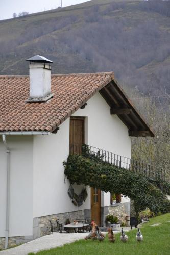 a white house with pigeons in front of it at CASA RURAL Arriaran in Leitza