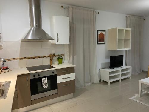 a kitchen with a stove and a tv in it at Pensión Cádiz in Cádiz