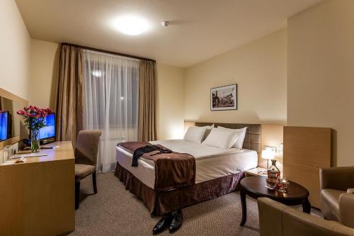 una camera d'albergo con letto e soggiorno di Sofia Palace Hotel by HMG a Sofia