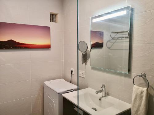 W łazience znajduje się umywalka, toaleta i lustro. w obiekcie Vista Paraíso by TOR w Puerto de la Cruz