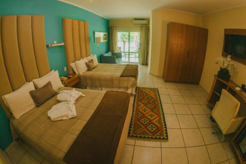 a hotel room with two beds and a television at La Dolce Villa in Avar&eacute;