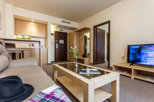 a living room with a couch and a television at Sofia Palace Hotel by HMG in Sofia