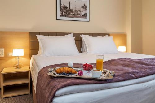 bandeja de comida en una cama en una habitación de hotel en Sofia Palace Hotel by HMG, en Sofía