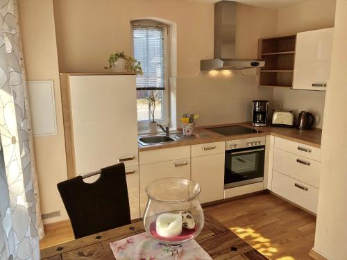 a kitchen with a glass of wine on a table at Ferienapartments Spreewaldwiesen in Vetschau