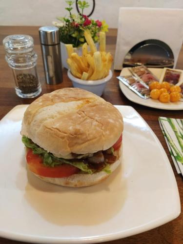 a white plate with a sandwich and french fries at Hotel Cabañas El Rincón de las Campanas in Nobsa