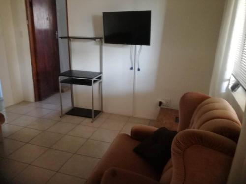 a living room with a couch and a flat screen tv at Hunters Self Catering Apartment in East London