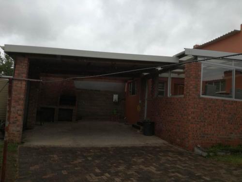 a brick house with an open garage with at Hunters Self Catering Apartment in East London