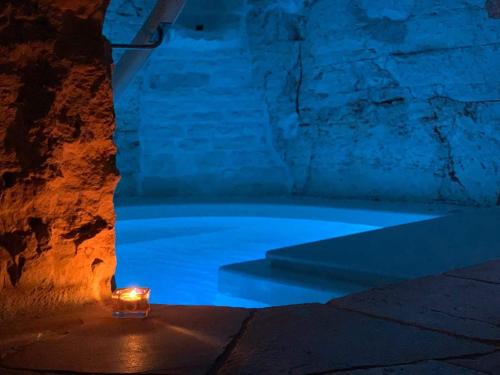 Una vela encendida sentada en una bañera por la noche en Trulli Occhi Di Pietra, en Alberobello