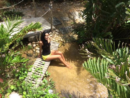 a woman sitting on a bench in a garden at WegoKite Stars in Taíba