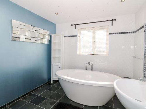 a bathroom with a white tub and a sink at Golygfa Ynys Island View in Amlwch