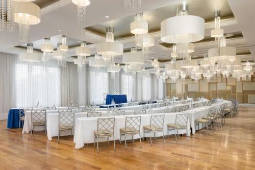 a banquet hall with white tables and chairs and chandeliers at Allegria Hotel in Long Beach