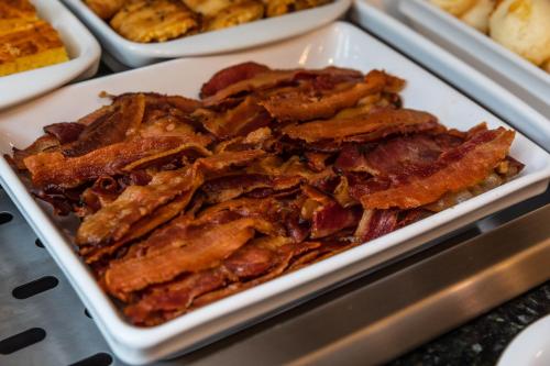 a white plate of bacon on a table at Viale Tower Hotel in Foz do Iguaçu