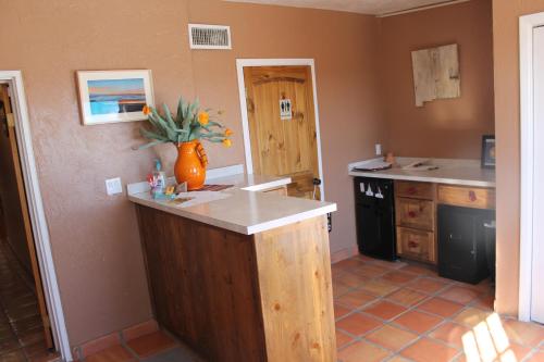 a kitchen with an island in the middle of a room at Adobe Rose Boutique Inn in Artesia