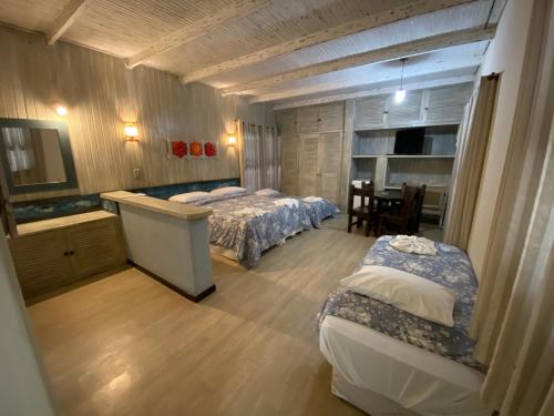 um quarto com 2 camas, uma mesa e cadeiras em Palace Hotel em Angra dos Reis