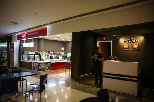 une personne debout dans un fast-food dans l'établissement TBS Rest & Go Transit Motel, à Kuala Lumpur