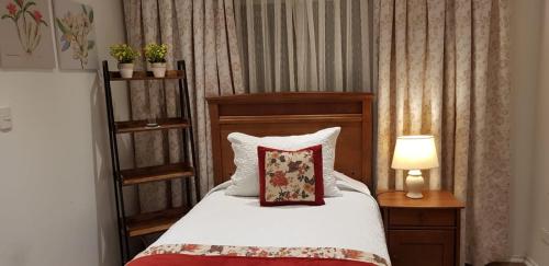 a bedroom with a bed with a pillow and a lamp at Hotel Puerta del Lago in Puerto Varas
